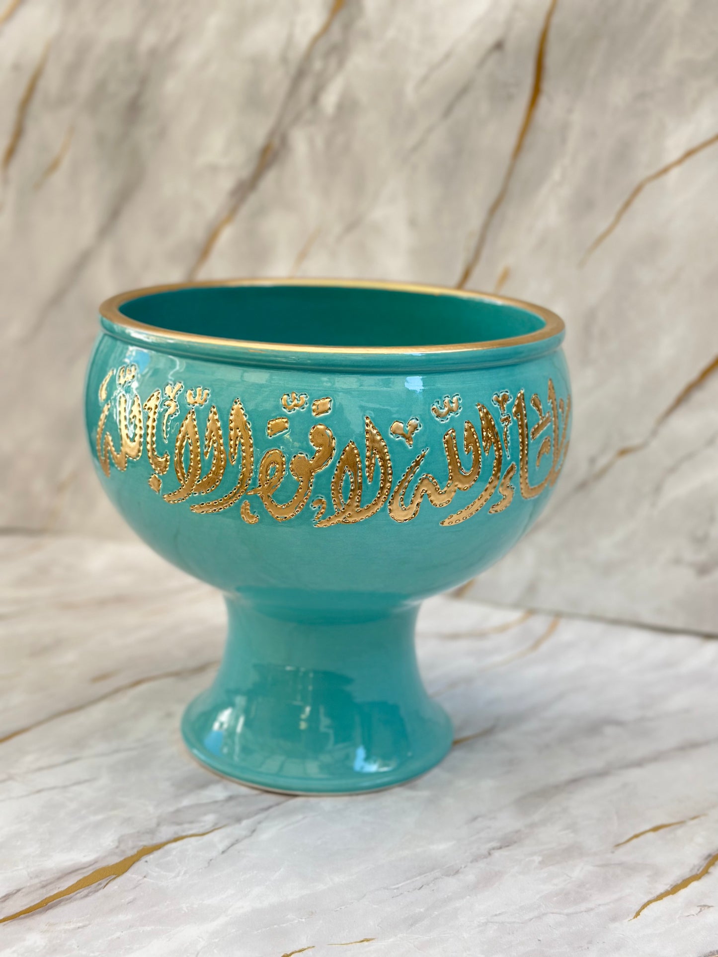 Introducing our Ceramic Pedestal Bowls, crafted to perfection with high-quality ceramics. Adorned with opulent gold Arabic calligraphy on vibrant turquoise or serene cream backgrounds, these bowls are versatile as elegant home accents or unique gifts.