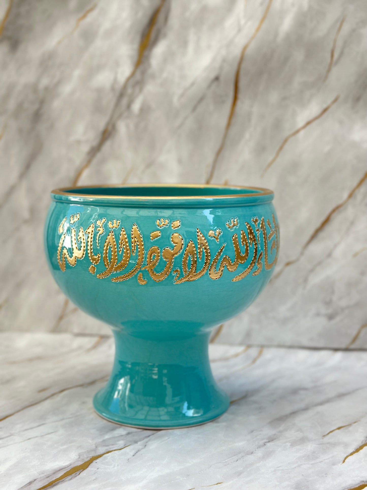 Add a touch of opulence with our Ceramic Pedestal Bowls, adorned with luxurious gold Arabic calligraphy - لا اله الا الله محمد رسول الله. Available in vibrant turquoise or serene cream, these bowls elevate any space with their elegant design and cultural significance.