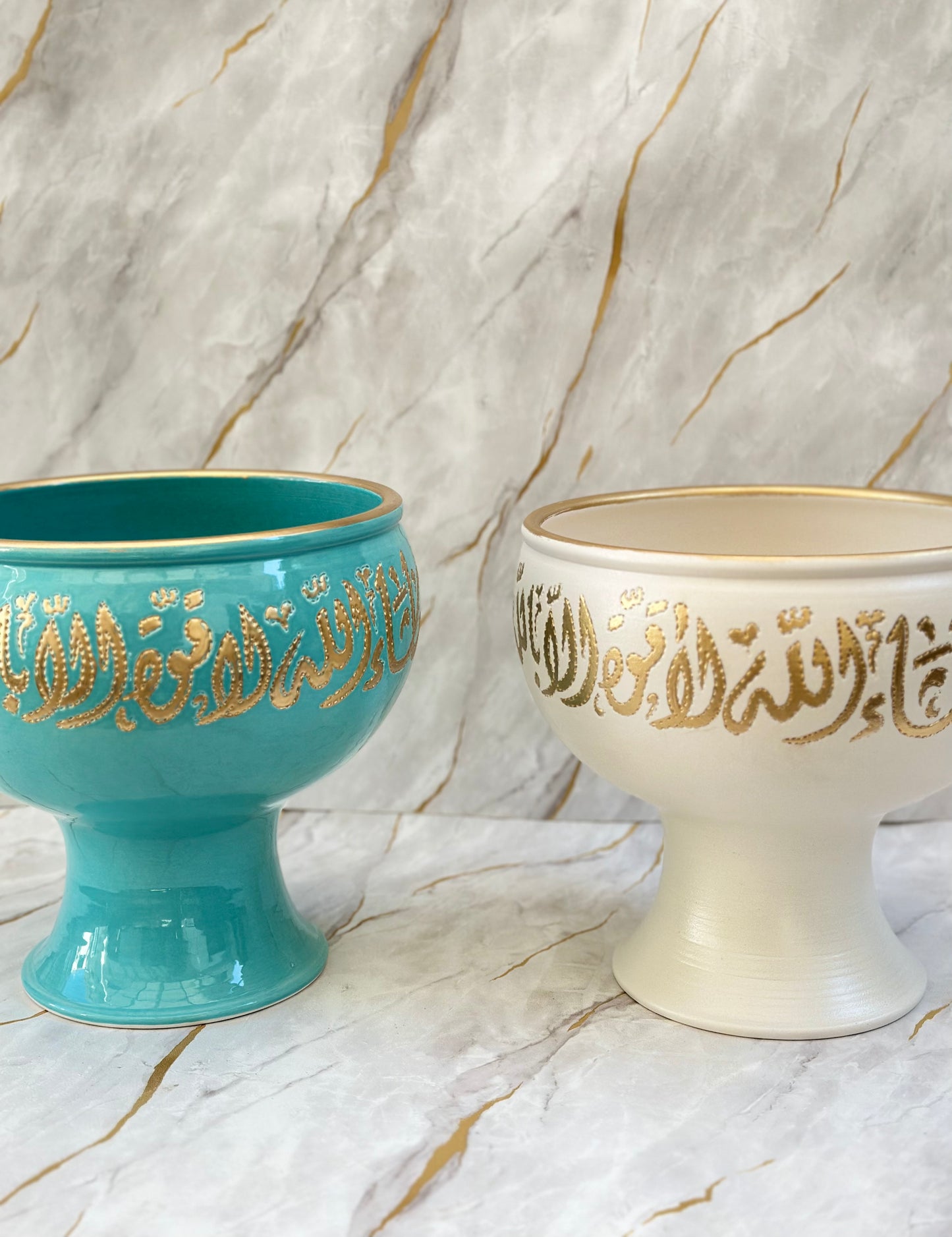 Elevate your decor with our Ceramic Pedestal Bowls, blending elegance and tradition. Adorned with opulent gold Arabic calligraphy - لا اله الا الله محمد رسول الله - against vibrant turquoise or serene cream, these bowls make captivating home accents or thoughtful gifts.