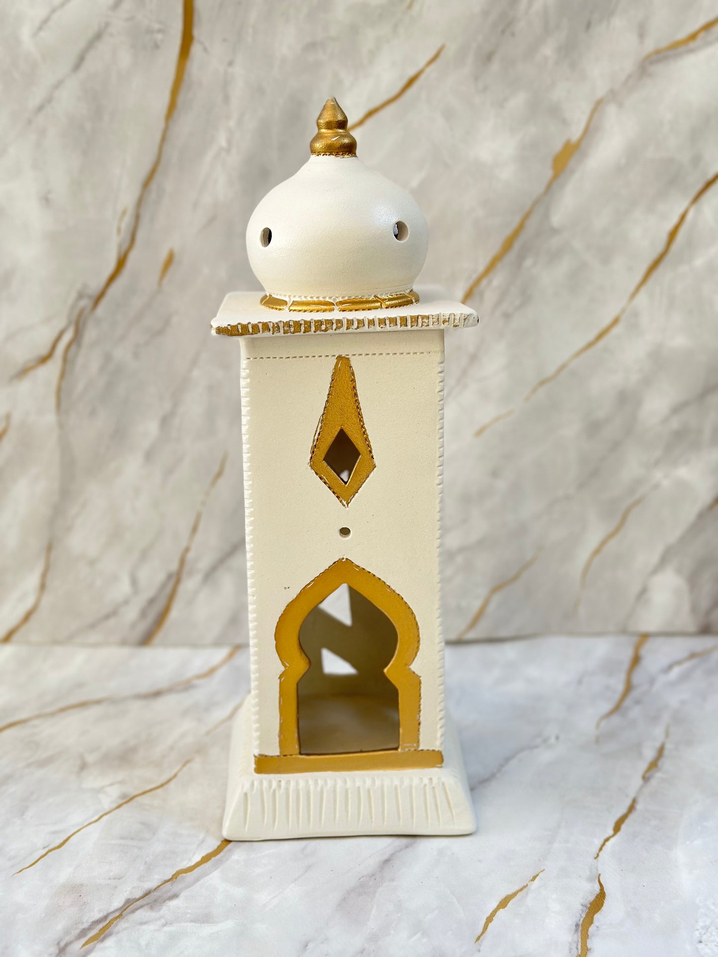 Elevate your Ramadan decor with our Ceramic Minaret, a stunning blend of cream and turquoise adorned with golden accents. Its minaret-inspired design not only diffuses incense gently but also adds an elegant touch to your sacred space.