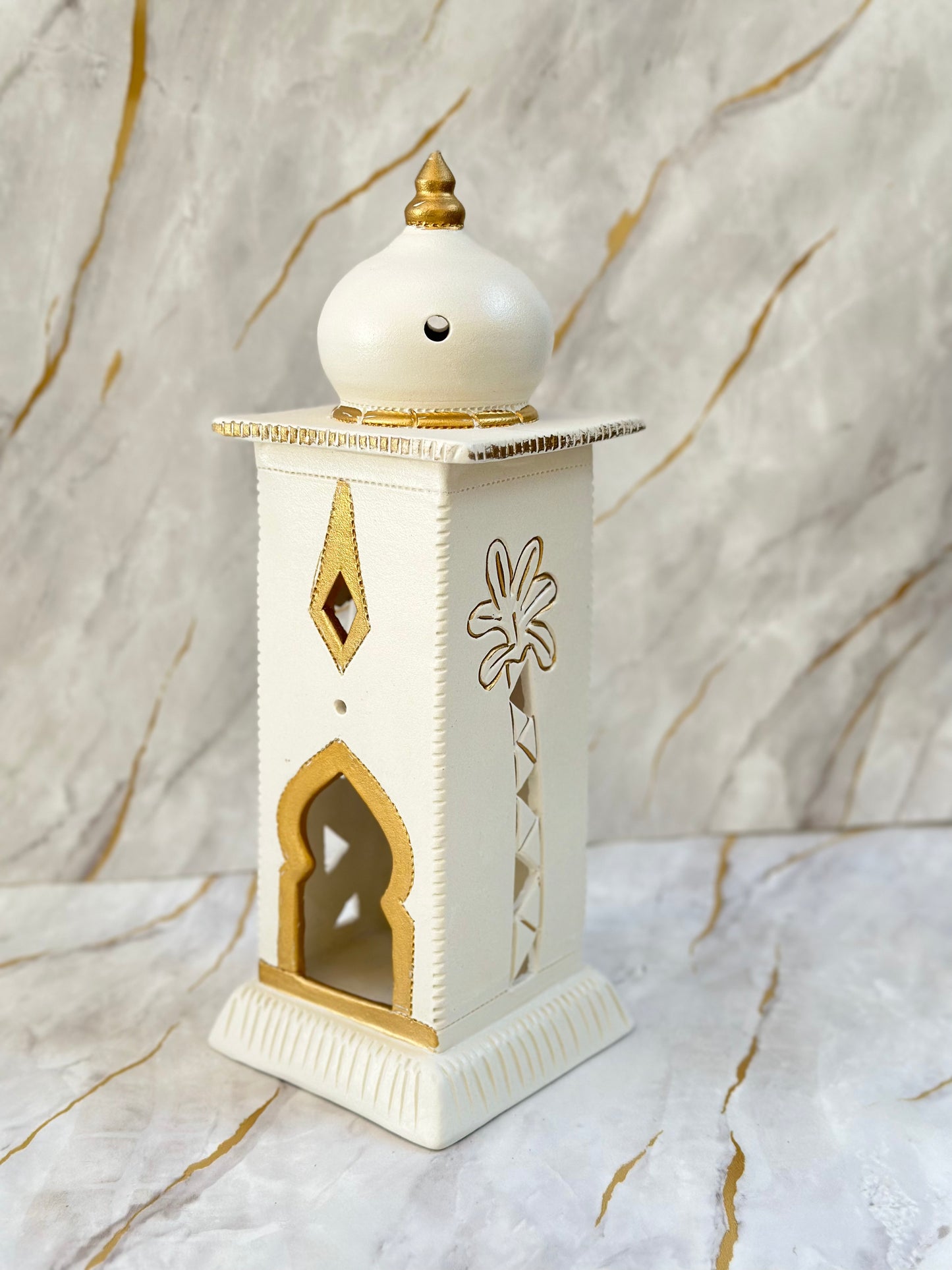 Embrace the spirit of Ramadan with our Ceramic Minaret, featuring a graceful design in cream and turquoise with shimmering gold accents. Perfect for holding electric candles or diffusing incense, it adds both beauty and tranquility to your home.