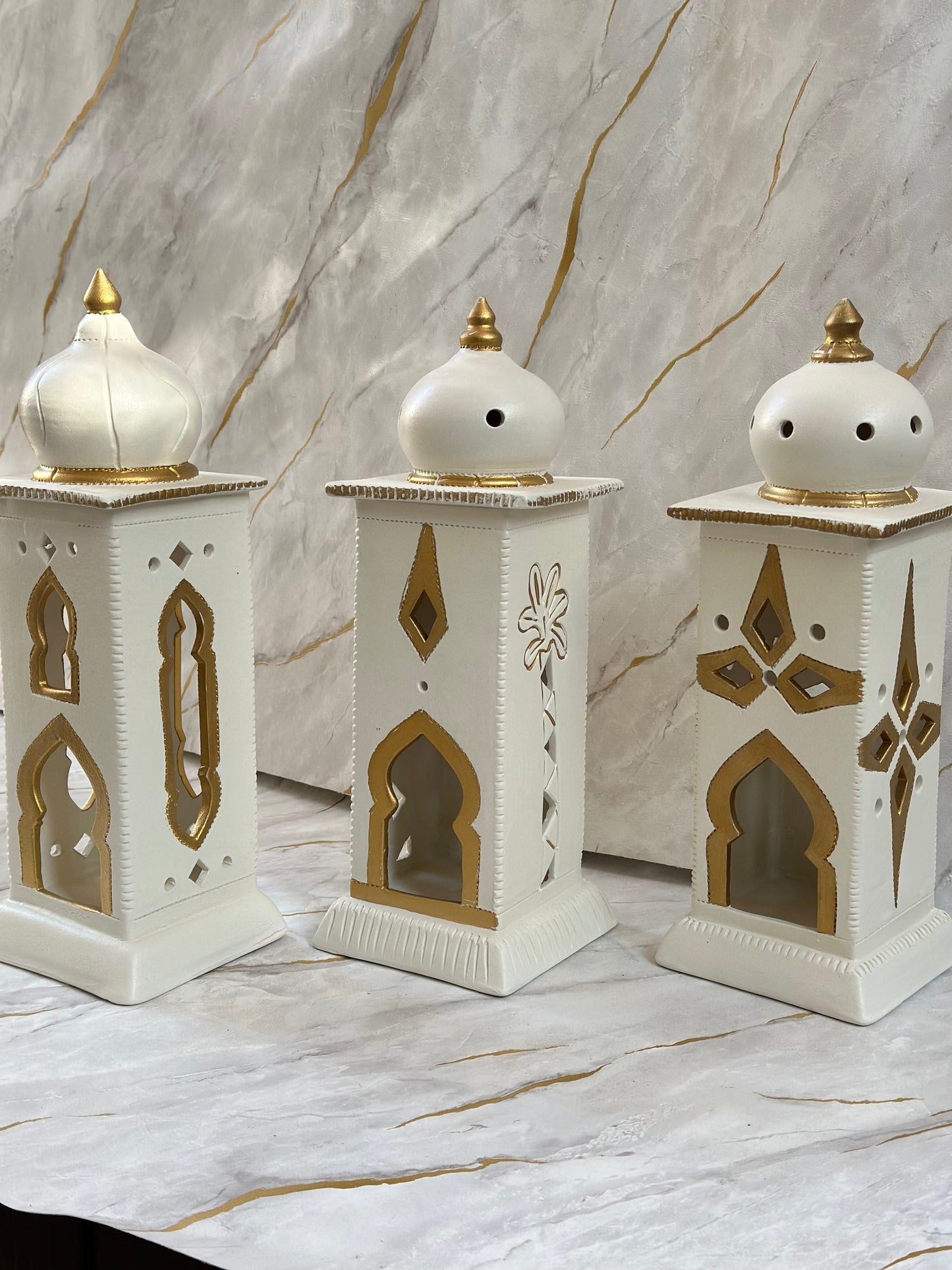 Enhance your Ramadan ambiance with our Ceramic Minaret, featuring a soothing blend of cream and turquoise adorned with golden highlights. Its minaret-inspired structure beautifully diffuses incense, fostering a serene environment.