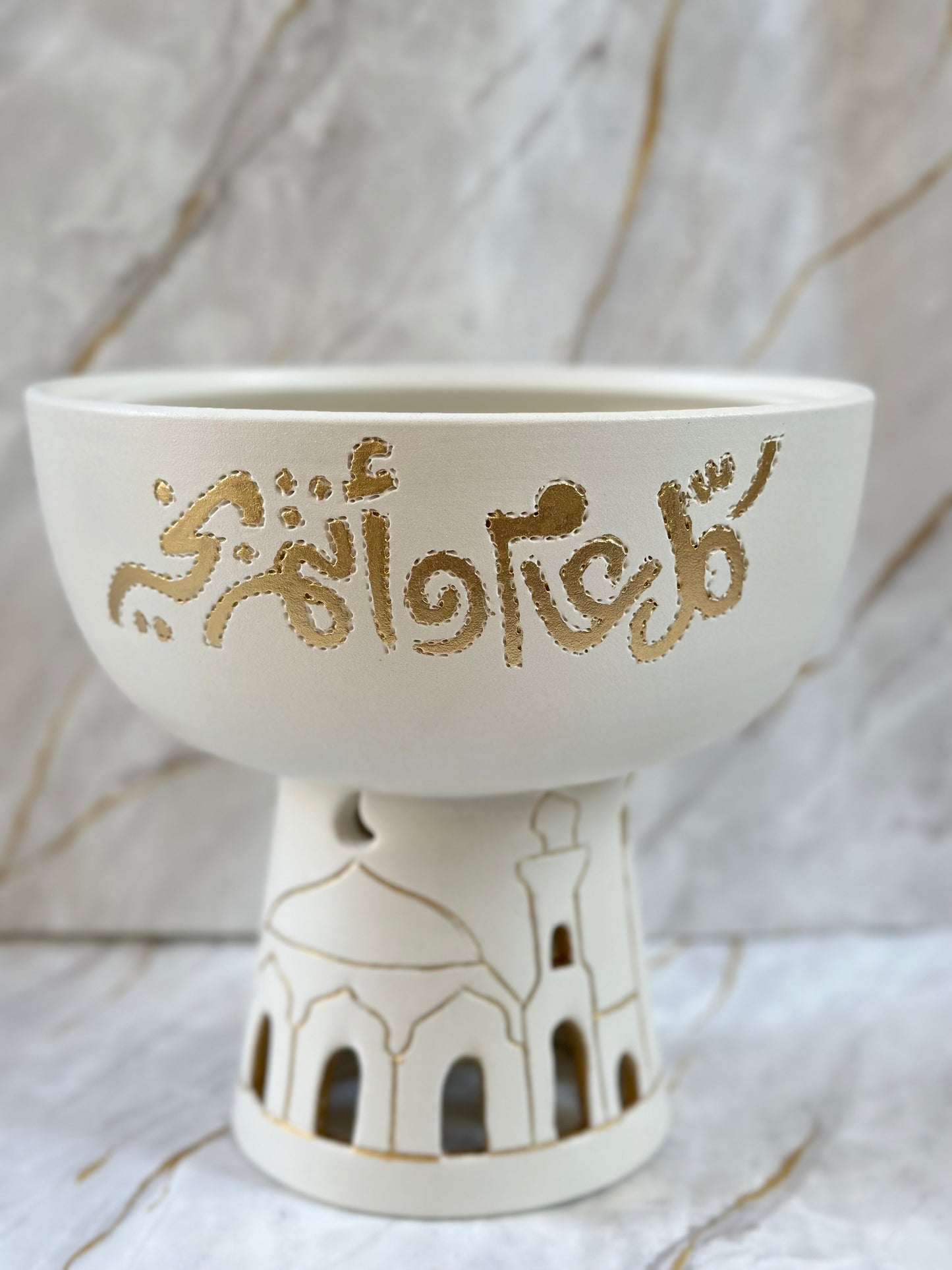 Elevate your Eid celebrations with our Mubarak Ceramic Bowl, a symbol of grace and spirituality. Handcrafted with intricate golden calligraphy and mosque silhouettes, this incense holder creates a serene atmosphere for moments of reflection during holy occasions.