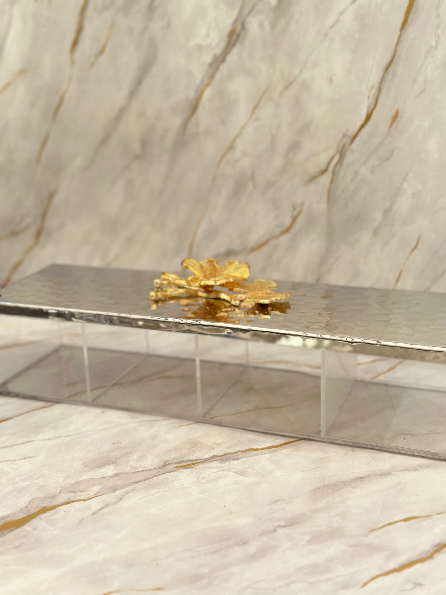 Showcase your treats with our Arabesque Metal Tray, featuring a mirrored base divided for versatility. Adorned with a golden floral motif and supported by clear acrylic legs, it adds elegance to any occasion. Ideal for serving chocolates and nuts in a luxurious setting.