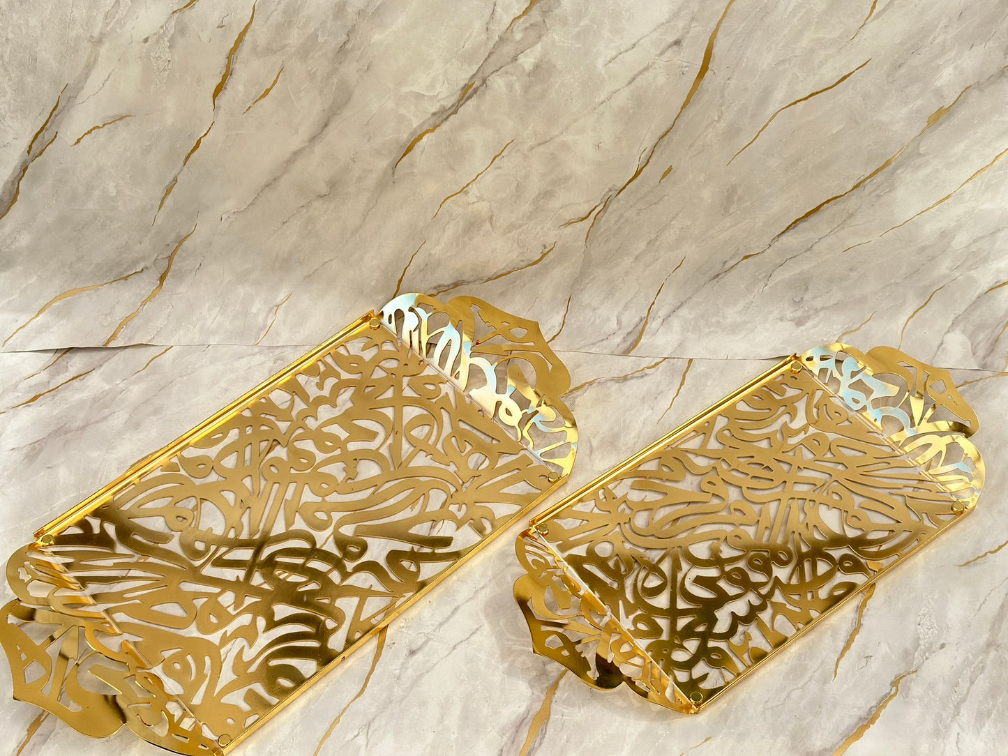 "Elevate your home decor with the Andalusia Glass Tray, featuring exquisite Arabic calligraphy on a mirror-like acrylic surface framed in aluminum with a golden finish. Ideal for both practical use and as a statement piece, this tray adds sophistication to any setting."