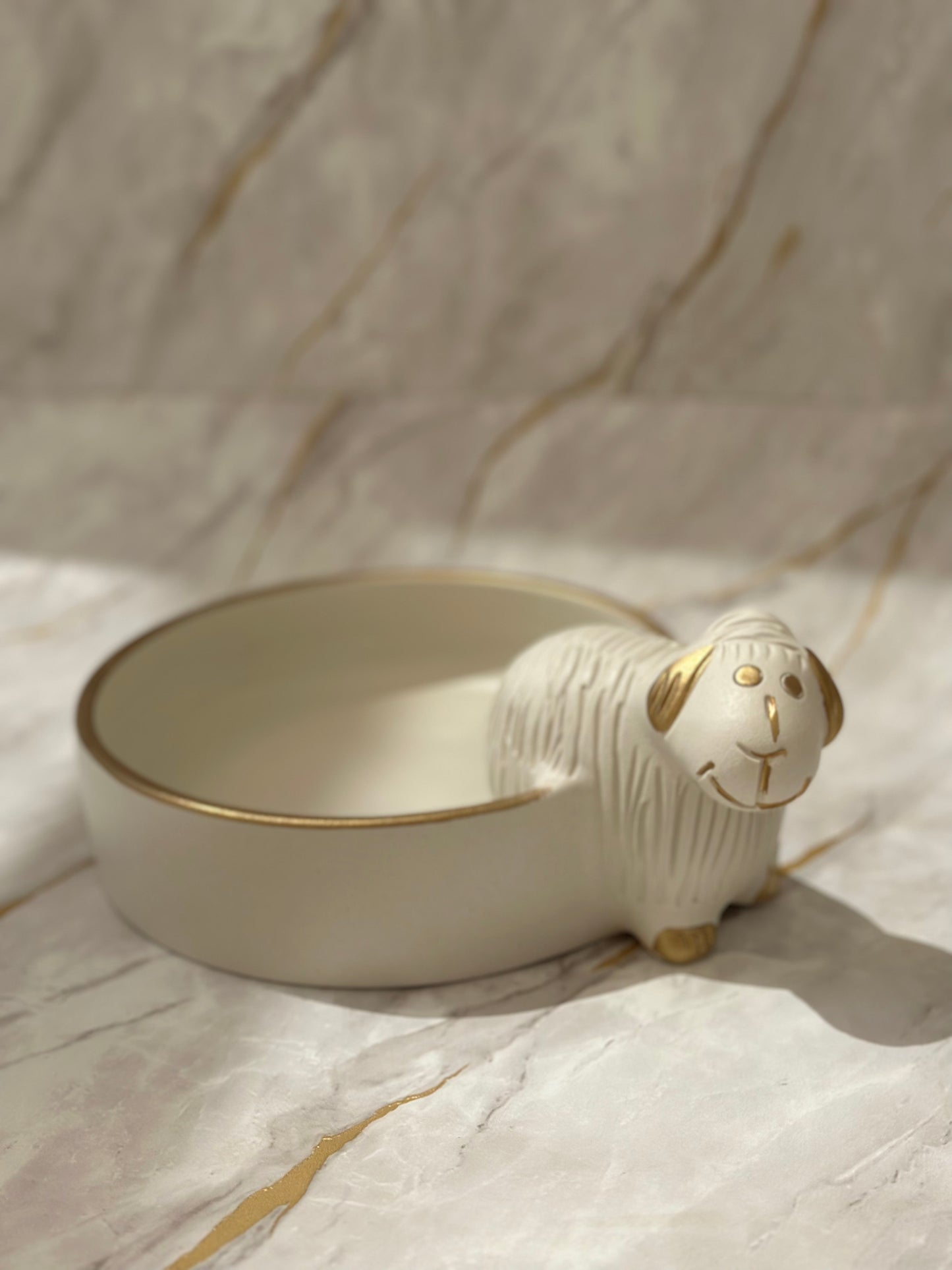 Introducing the Ceramic Sheep Bowl, a delightful fusion of charm and sophistication. Handcrafted with a cream-colored glaze and a touch of gold, this bowl doubles as a functional art piece. Whether on display or in use, it adds a touch of whimsy to any space.